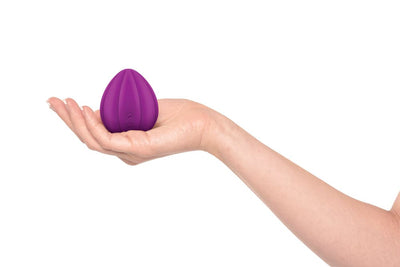 Front-facing clitoral vibrator magenta being held in white woman's palm